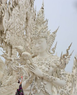 White sculpture holding lotus flowers at the famous wat rong khun, also known as the white temple,