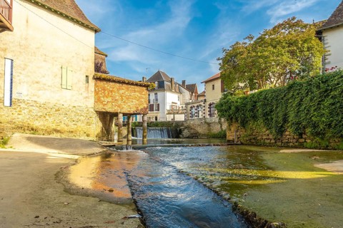 Scenic view of a small waterfall flowing through the charming village of salies de bearn in the