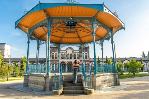 Tourist ascending stairs of a gazebo in a park in salies de bearn, france, enjoying a summer