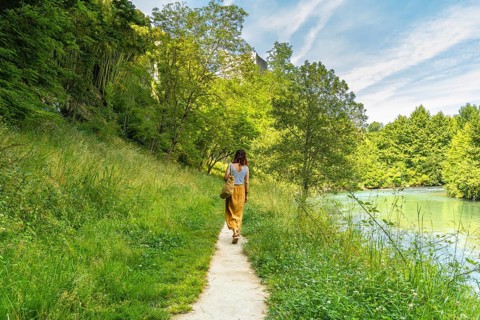 Tourist enjoying a peaceful walk along the gave d'oloron river in sauveterre de bearn, a charming