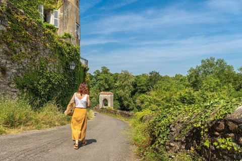 Tourist walking on a sunny day in sauveterre de bearn, france, exploring the medieval architecture