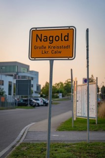 Town sign of Nagold on a street with modern buildings in the background, Nagold, district of Calw,