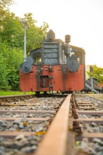 Close-up of an old steam locomotive on railway tracks surrounded by green nature, Nagold, district