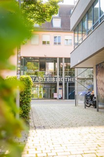 City library entrance in an urban environment with glass façade and green landscape, Nagold, Calw