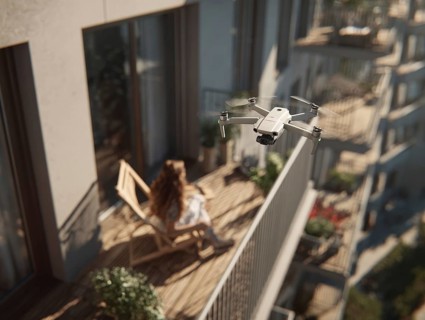 Ein Fernpilot steuert sein Quadrocopter, Drohne in einem dicht besiedeltem Wohngebiet und nähert