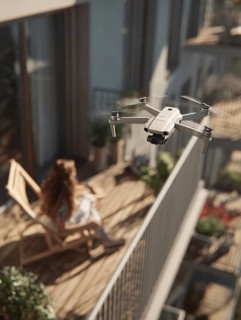 Ein Fernpilot steuert sein Quadrocopter, Drohne in einem dicht besiedeltem Wohngebiet und nähert