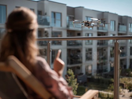 Ein Fernpilot steuert sein Quadrocopter, Drohne in einem dicht besiedeltem Wohngebiet und nähert