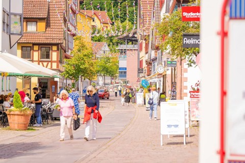 Lively street in an old town with passers-by and hustle and bustle on a sunny day, small town pearl
