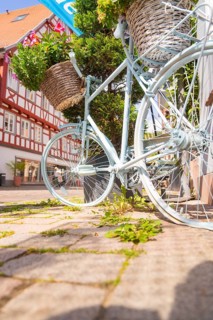 Close-up of a bicycle in front of half-timbered houses in sunlight, small town of Perle Calw,