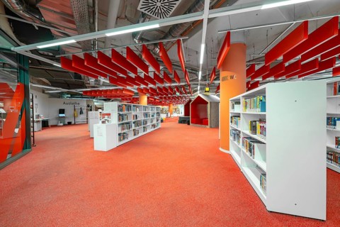 A modern library with eye-catching red and white elements creates a lively atmosphere, Munich,