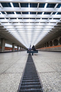 Symmetrical station concourse with modern benches and bright lighting, Munich, Germany
