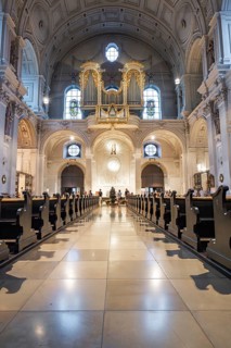 Solemn interior view of a church with altar and organ in the background, Munich, Germany