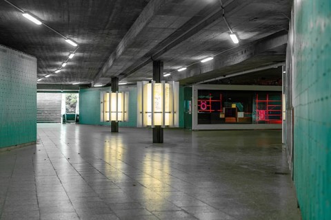 A modern, urban tunnel with coloured neon lights creates an industrial-looking atmosphere, Munich,