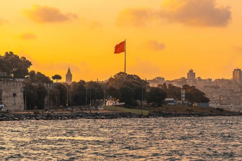 Scenic sunset view of istanbul's cityscape, featuring the prominent galata tower and a waving