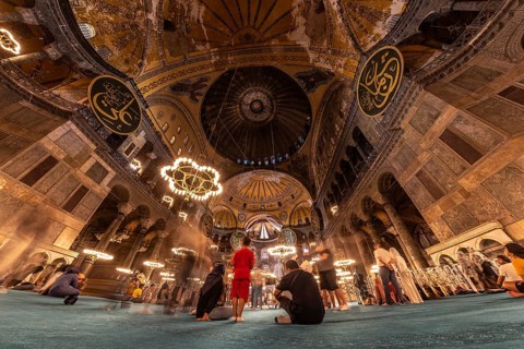Tourists contemplating the impressive architecture and intricate details of the hagia sophia, a