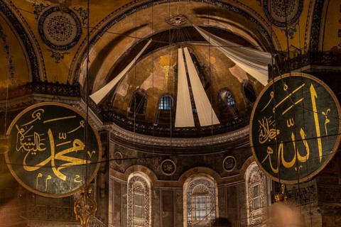Interior view of hagia sophia showcasing islamic calligraphy, the central dome, and architectural