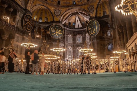 Tourists admiring the interior of the magnificent hagia sophia in istanbul, turkey, illuminated by