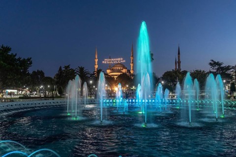 Colorful illuminated fountains enhance the beauty of hagia sophia at twilight in istanbul, creating