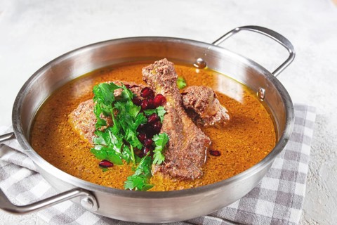 Fesenjan, an Iranian dish, stewed chicken, in a nut-pomegranate sauce, in a saucepan, light