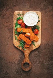 Fried fish nuggets, with white sauce, arugula and cherry, no people