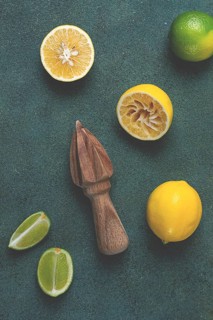 Wooden citrus reamer, manual lemon juicer, made of acacia wood, with citrus fruits on the table,