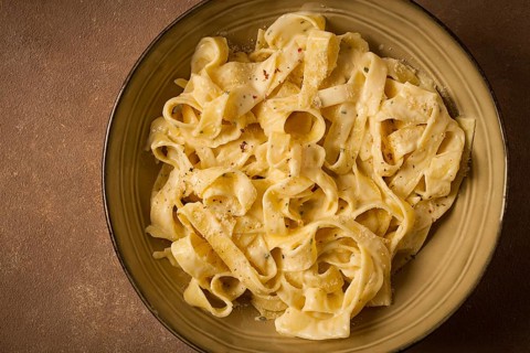 Fettuccine, tagliatelle, in creamy garlic sauce, Italian traditional cuisine, pasta carbonaro