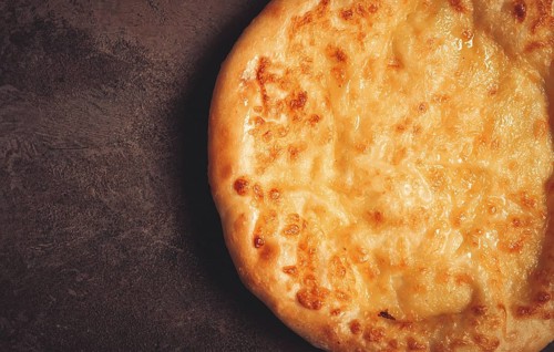 Khachapuri in Megrelian, a traditional Georgian dish, flatbread with cheese, top view, no people
