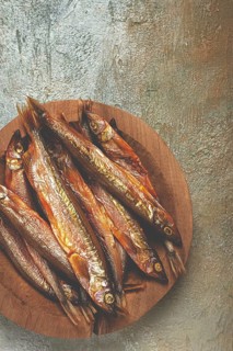 Cold smoked capelin, on a wooden bowl, top view, no people
