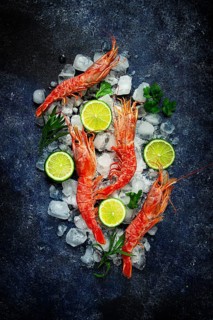 Langoustines, Australian, freshly frozen on ice, top view, lime and greens