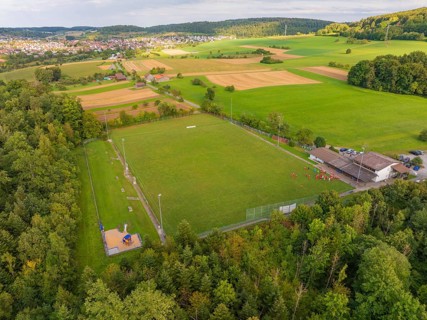 Sports field and buildings surrounded by trees and fields near a village, VFL Stammheim, Calw,