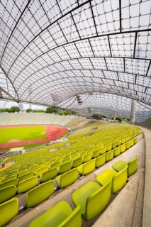 Stadium interior with yellow seats and an elegant roof design, Olympiapark, Munich, Germany