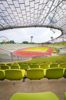 Empty modern stadium with central view of running track and striking glass architecture,