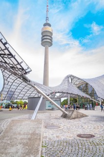 Impressive architecture below a television tower with modern design under a blue sky, Olympic Park,