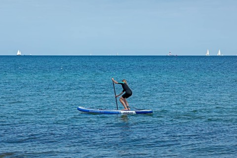 Girl stand-up paddling, Strande, Schleswig-Holstein, Germany