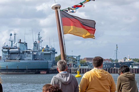 Toruists on excursion boat, flag, Bundeswehr ships, naval base, Kiel, Schleswig-Holstein, Germany