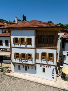 A single historic building with wooden windows and a red roof on a sunny day, aerial view,