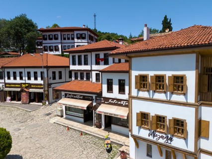 Historic old town with white buildings and red roofs, shops on a cobblestone street under a blue