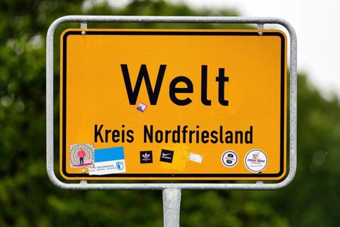 Place name sign world, inscription, many stickers, Eiderstedt peninsula, North Frisia, Germany