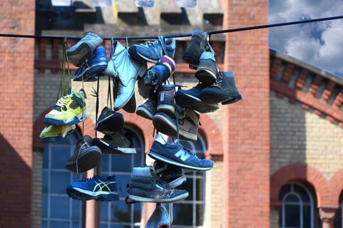 Shoes hanging on a leash in the courtyard of a residential home for addicts, each shoe a reminder