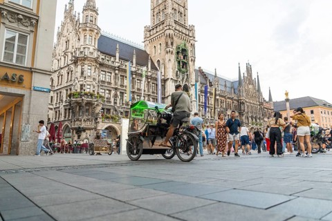 Lively town hall square with tourists in front of impressive Gothic architecture, Marienplatz,