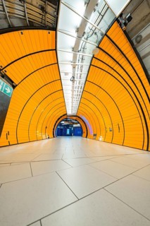 Orange tunnel with symmetrical structures and tiles leading into the depths, Marienplatz, Munich,