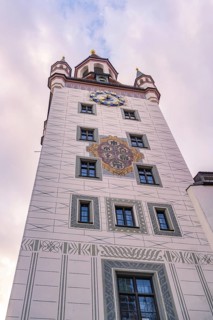 Decorated tower with clock in front of a pink cloudy sky, Munich, Germany