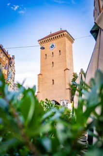 Historic clock tower in an urban setting with blue sky, Munich, Germany