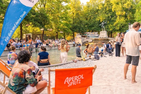 Summer atmosphere with numerous people at the fountain, Munich, Germany