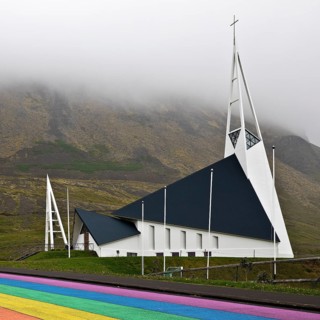 Street painted in the colours of the rainbow and the fish-shaped church designed by Hákon