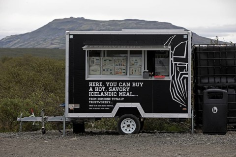 Food truck in the car park at Brúarfoss waterfall in the countryside with opening hours from 11 am