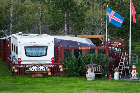 Icelandic permanent camper with full decoration and Icelandic flag at the campsite in Uthlid in