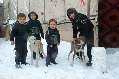 Displaced Syrian families and children living in refugee camps during harsh winter conditions,