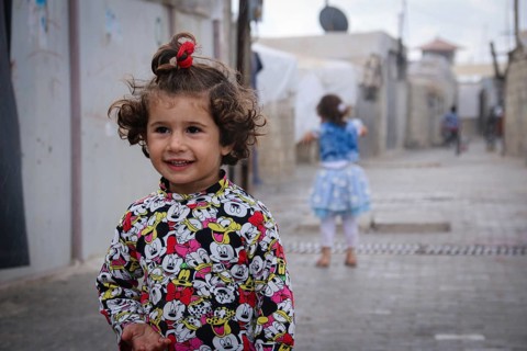 A Syrian refugee child photographed in a camp, reflecting the harsh living conditions of displaced