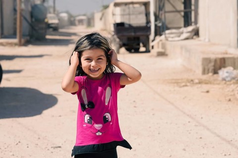 A Syrian refugee child photographed in a camp, reflecting the harsh living conditions of displaced